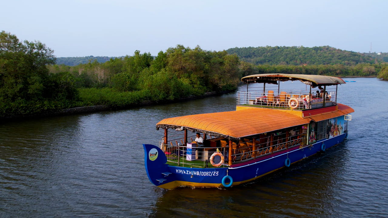 Houseboat gliding through the Vellikkeel mangrove canal in Kannur, Kerala