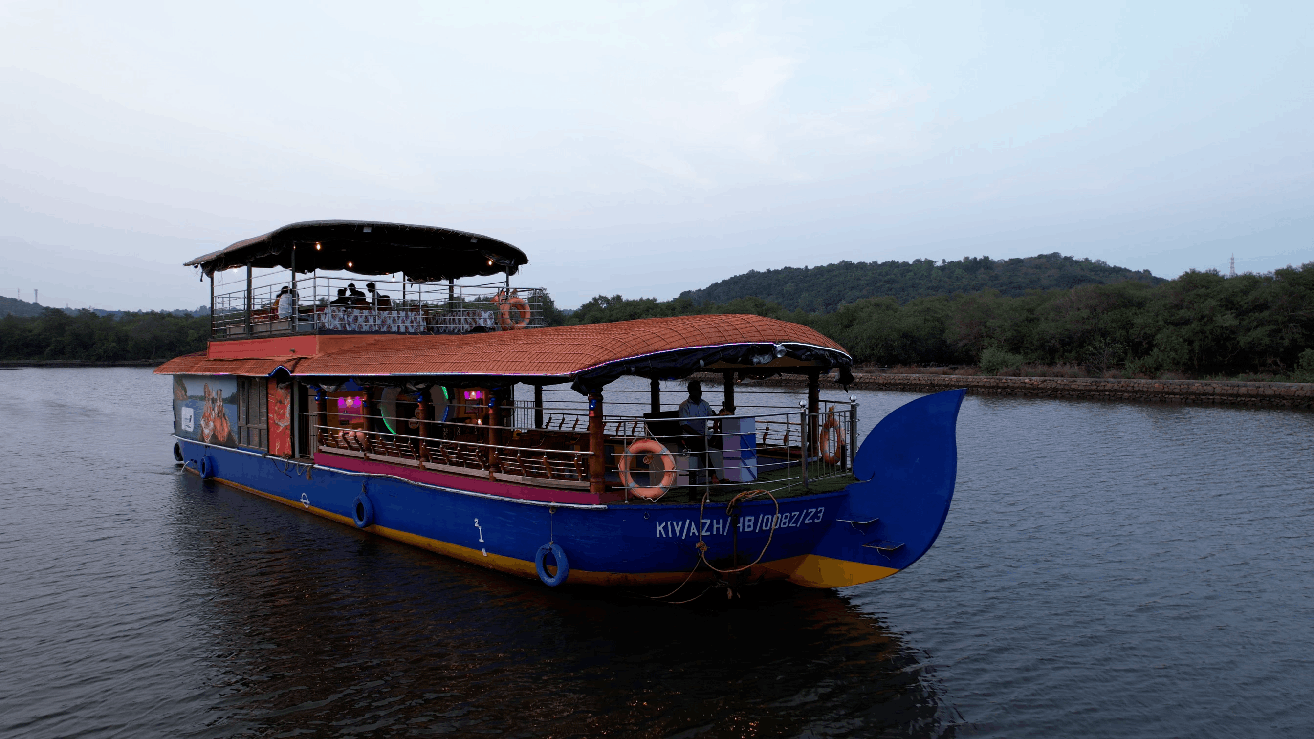 Lit houseboat at dusk for an overnight stay on the Vellikkeel river